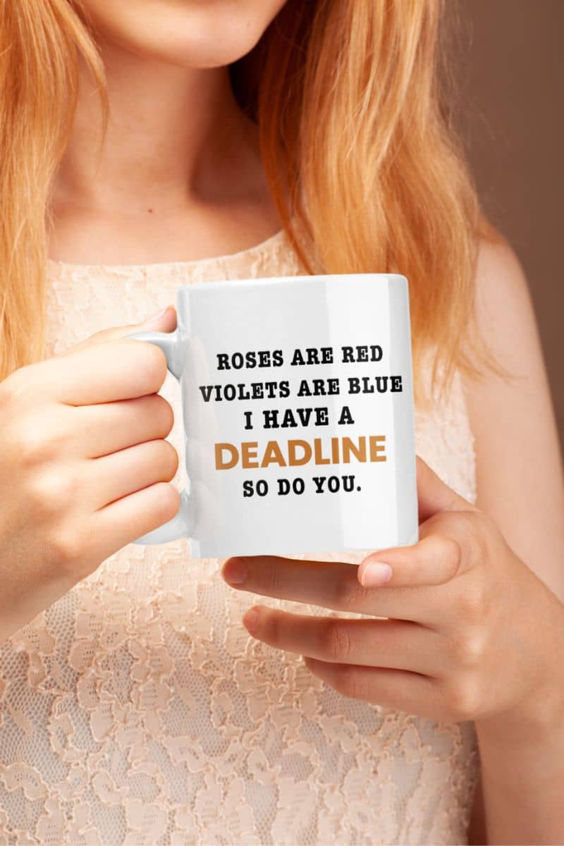office desk mug with a person holding a mug with text 'Roes are red, violets are blue. I have a deadline so you do'