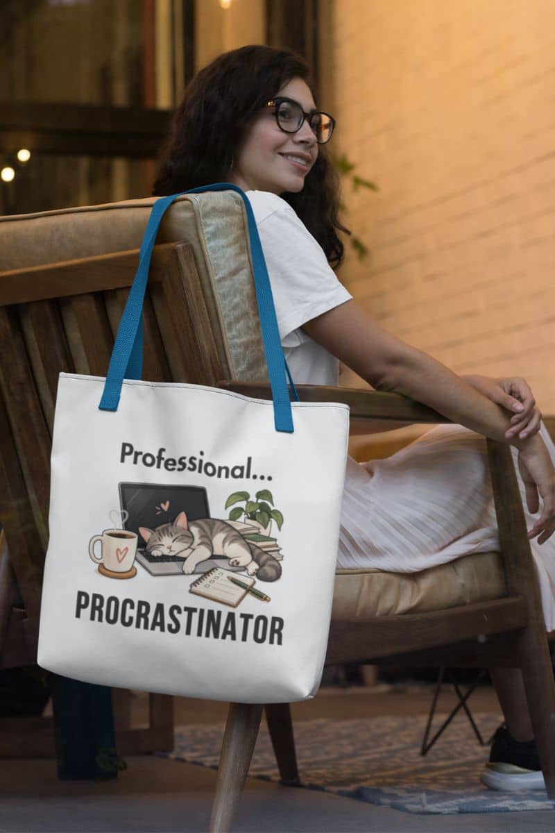 a office humor bag featuring the text 'Professional Procrastinator', hanging on the wooden chair in the coffee shop.