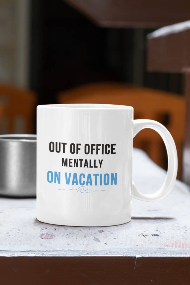 office humor mug with a white mug with text 'Out of office mentally on vacation' on a surface.