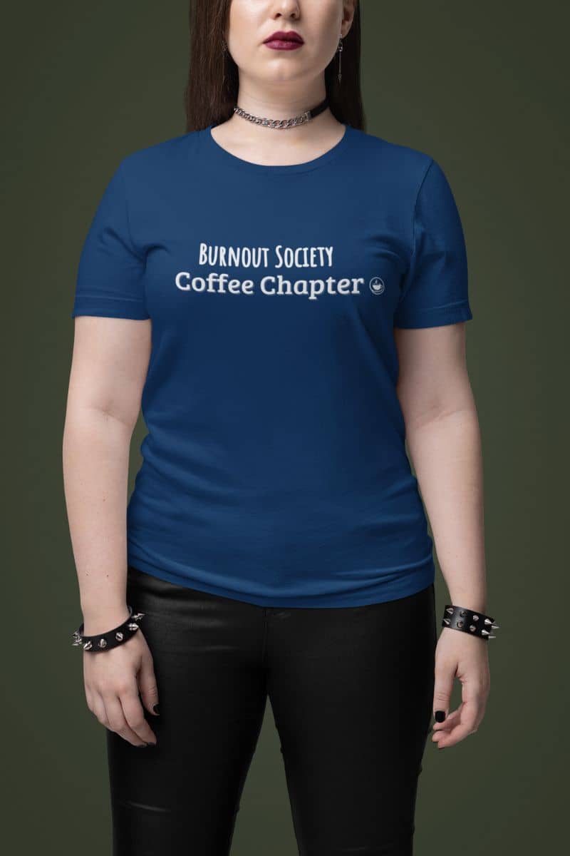 overworked but caffeinated shirt with a person wearing a blue t-shirt with 'Burnout Society Coffee Chapter' text on a dark background