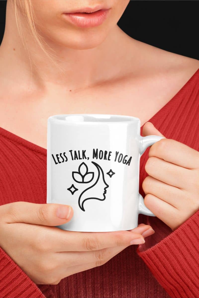 peaceful morning mug with a person holding a white mug with 'Less Talk, More Yoga' text and design.