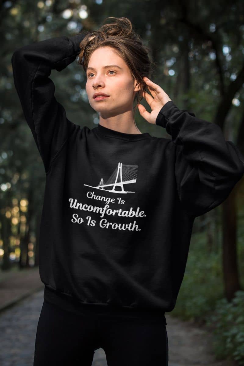 personal development sweatshirt with a person wearing a black sweatshirt with text 'Change Is Uncomfortable. So Is Growth' in a forest setting