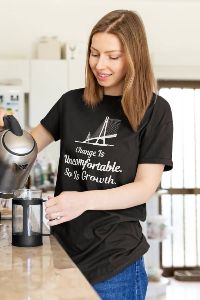 personal development tee with a woman wearing a black t-shirt with a motivational quote 'Change Is Uncomfortable. So Is Growth' in a kitchen.