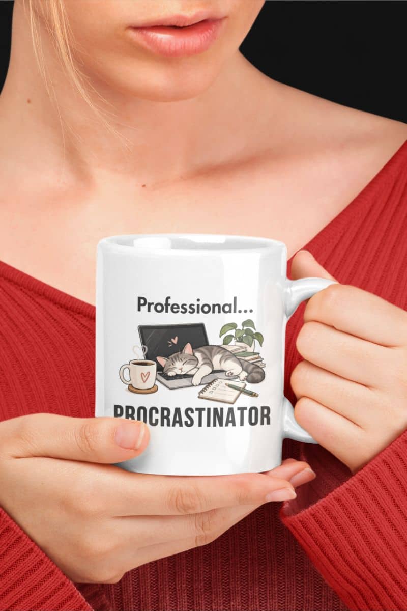 procrastination mug with a person holding a white ceramic mug that reads 'Professional Procrastinator'