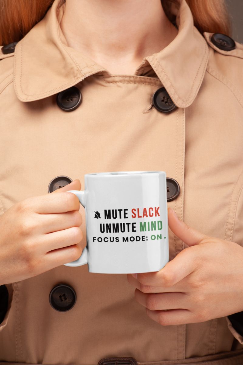 remote work coffee mug with a person holding a mug with text 'Mute Slack, Unmute Mind. Focus Mode: On' in a beige coat