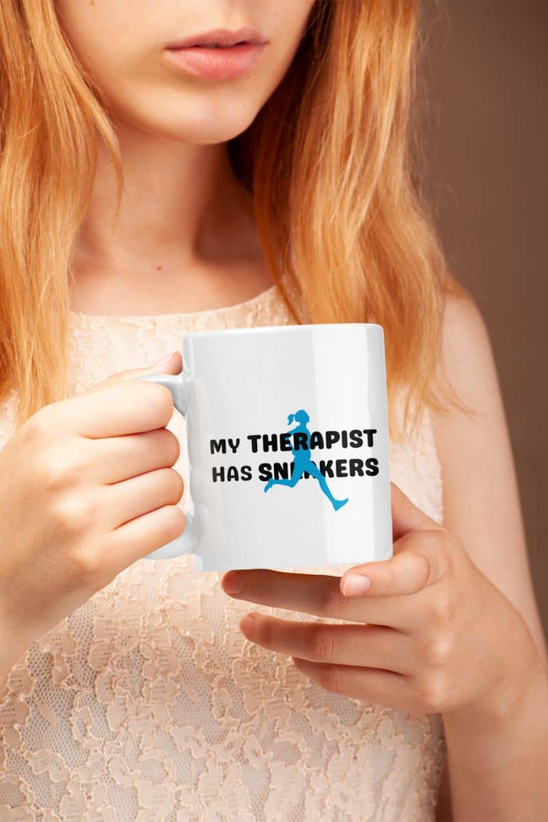 runner mug with a person holding a mug with 'My Therapist Has Sneakers' text
