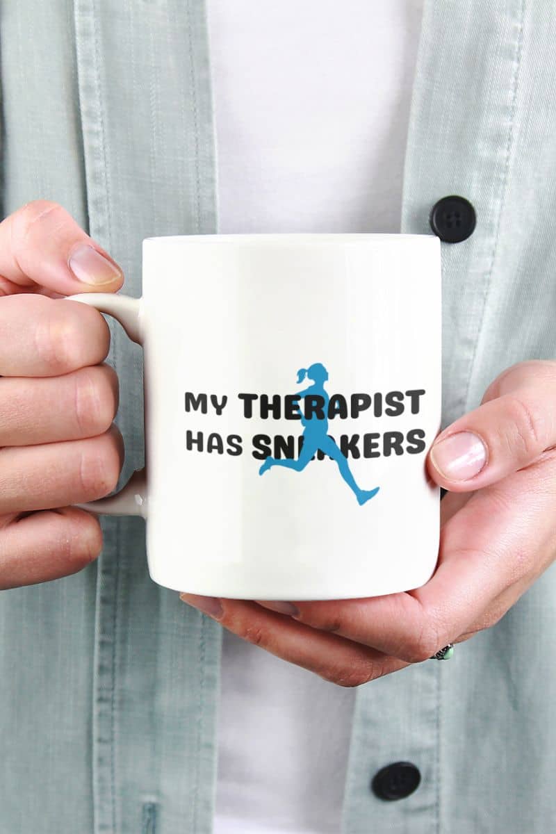 running humor mug with a person holding a mug with 'My Therapist Has Sneakers' text and graphic