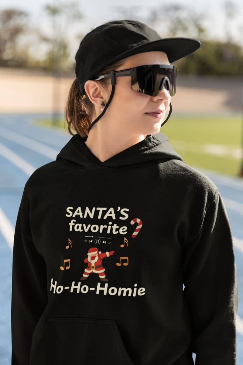 santa humor hoodie with a person wearing a black hoodie with 'Santa's favorite Ho-Ho-Homie' text and graphics on a track.