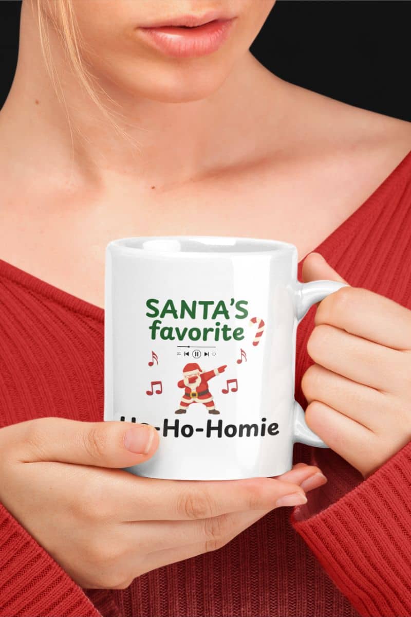 santa meme mug with a person holding a white mug featuring the text 'Santa's Favorite Ho-Ho-Homie'