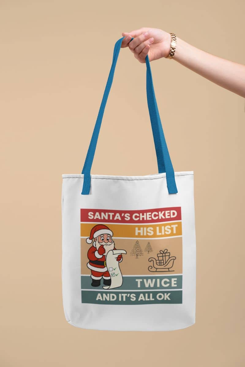 santa shopper bag with a tote bag with Santa Claus graphic and text 'Santa's Checked His List Twice And It's All Ok' on a beige background