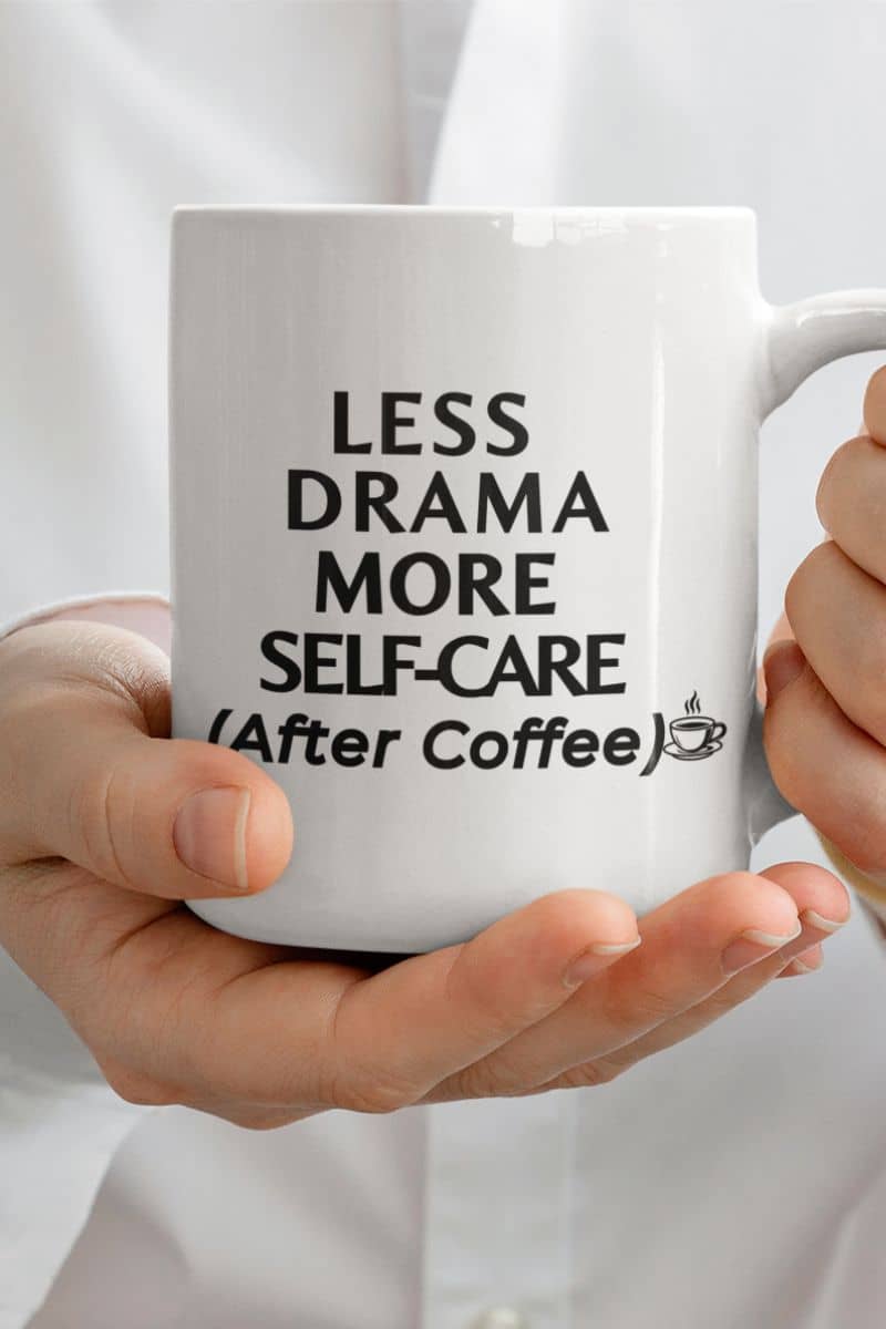 sarcastic coffee mug with a person holding a white mug featuring the text 'Less Drama, More Self-Care (After Coffee)'