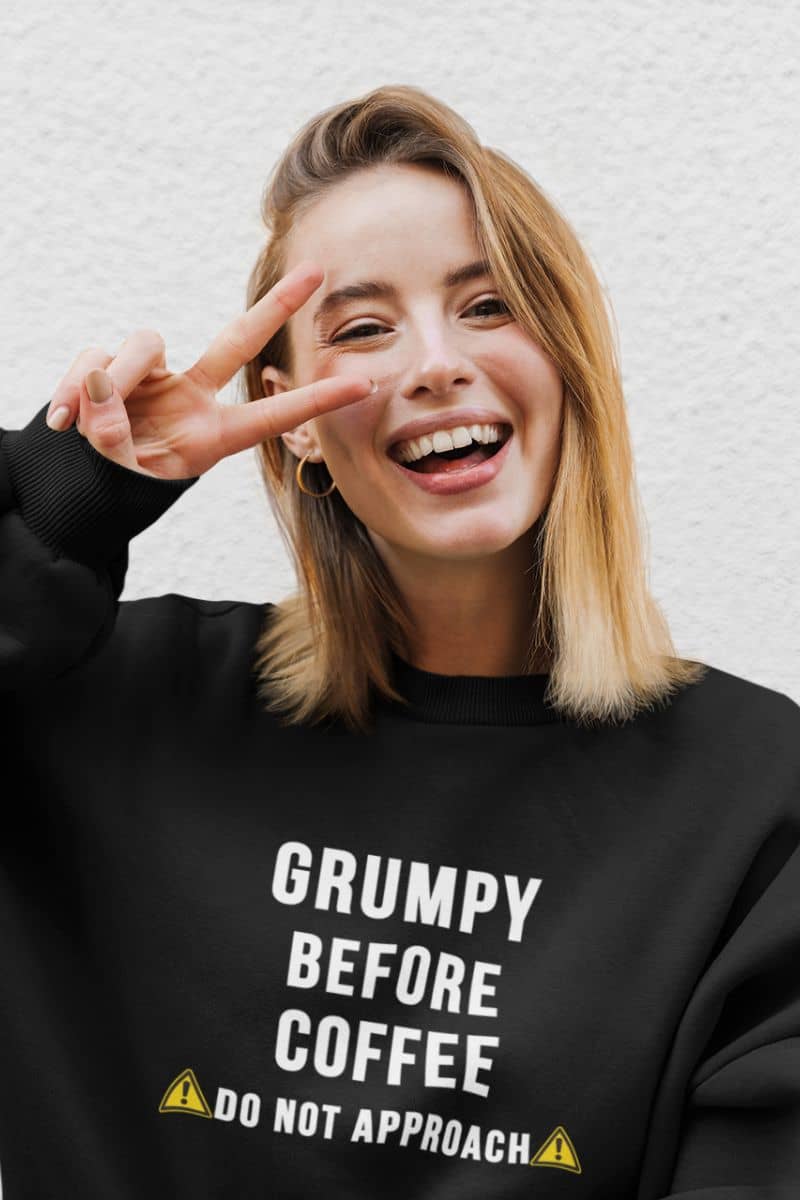 sarcastic crewneck sweatshirt with a women wearing a sweatshirt featuring the text 'Grumpy before coffee, do not approach'