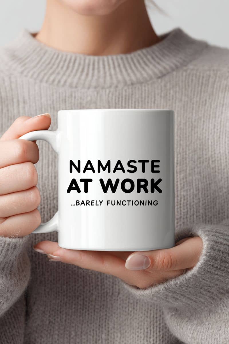sarcastic quote mug with a person holding a mug with text 'Namaste at Work...Barely Functioning'