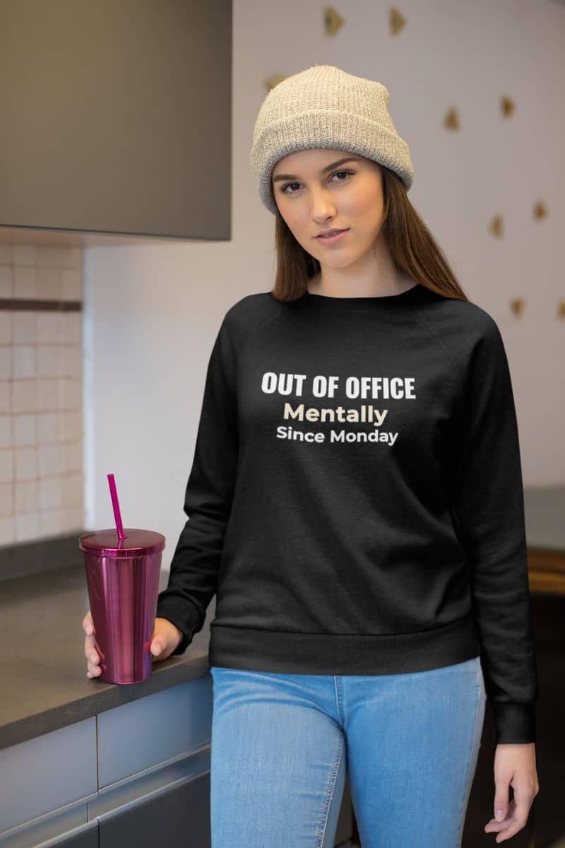 sarcastic work sweatshirt with a woman wearing a sweatshirt with text 'Out of Office. Mentally Since Monday.'