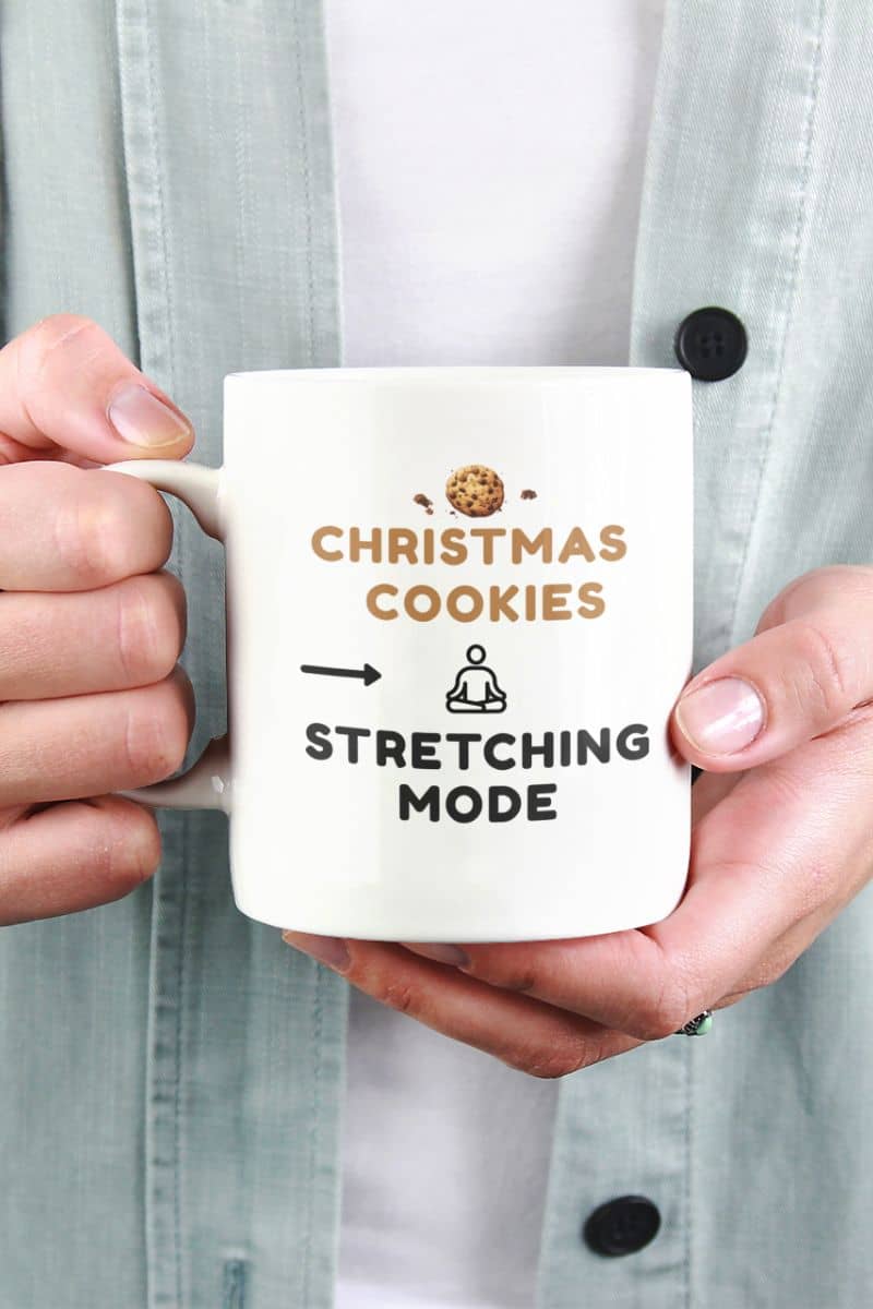 self care christmas mug with a person holding a mug with 'Christmas Cookies, Stretching Mode' text