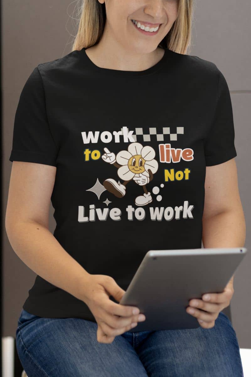 self-care quote shirt with a person wearing a black t-shirt with a motivational quote 'Work to Live, Not Live to Work' and holding a tablet.