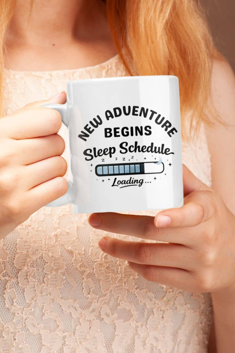 sleep deprived mug with a person holding a mug with text 'New adventure begins sleep schedule loading' against a neutral background