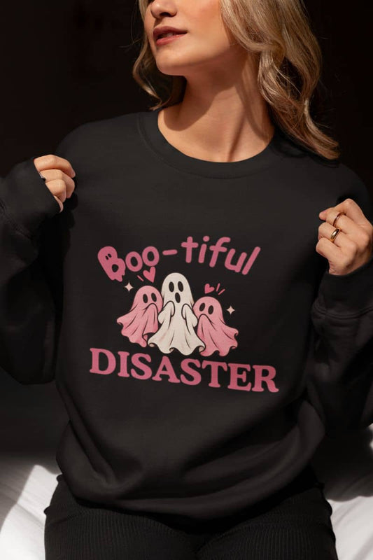 A woman wearing a spooky season sweatshirt with a pink and white graphic that reads 'Boo-tiful Disaster' with three ghosts