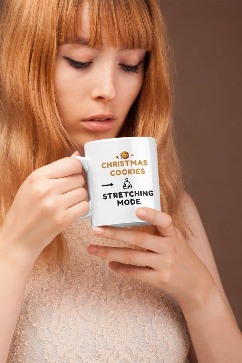 stress relief quote mug with a woman holding a mug with text 'Christmas cookies & stretching mode' against a brown background