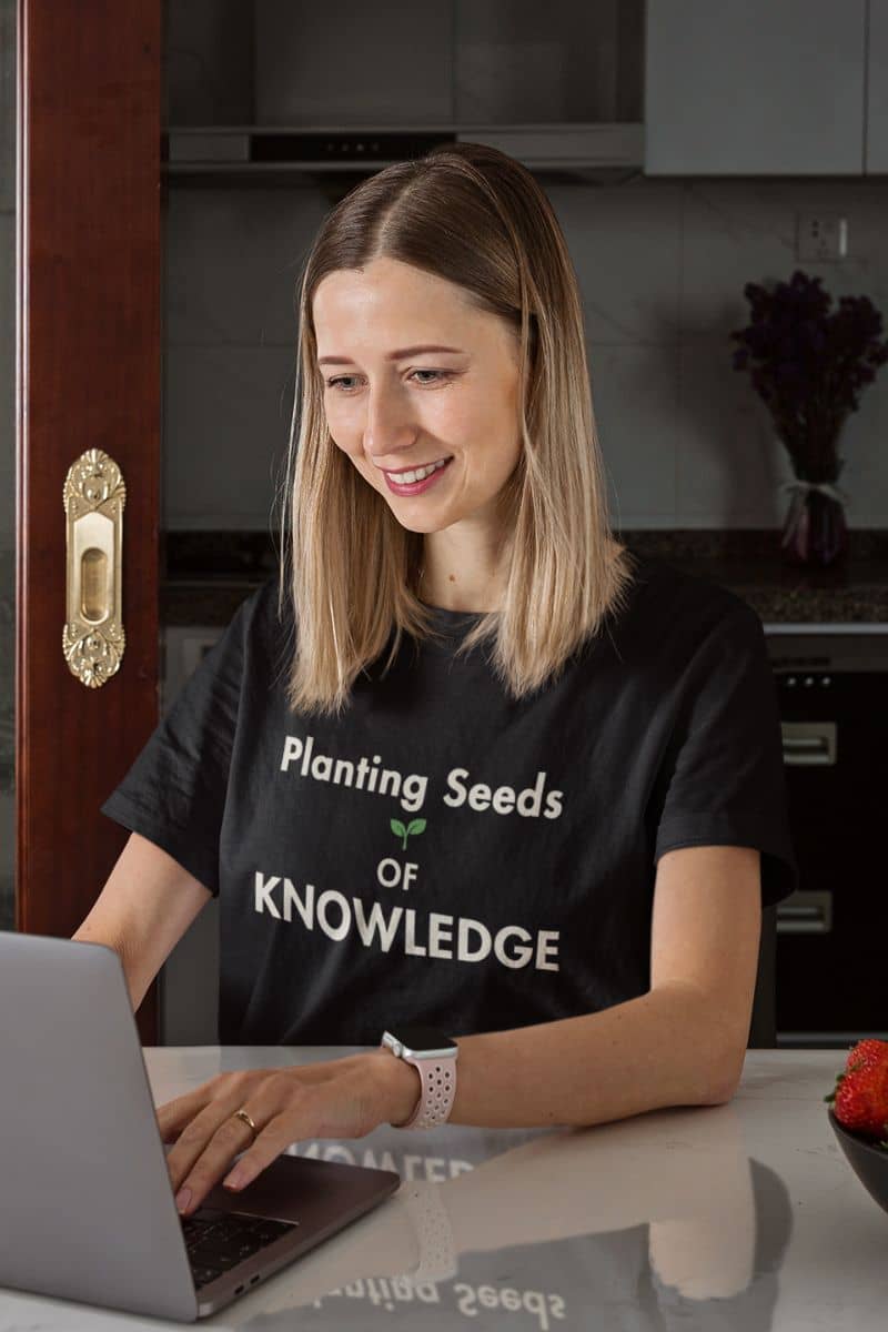 teacher appreciation shirt with a woman  wearing a black t-shirt that reads 'Planting Seeds OF KNOWLEDGE' 