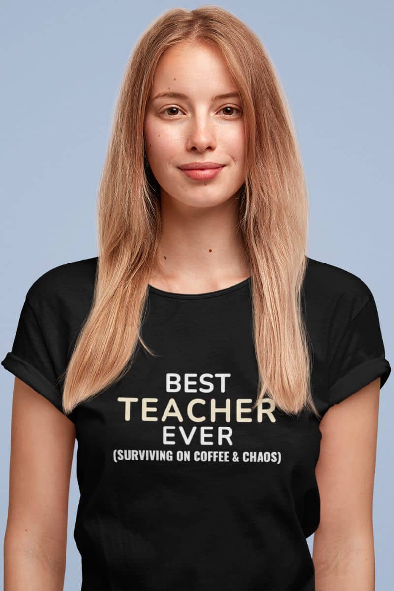 teacher humor t-shirt with a person wearing a black t-shirt with text 'Best Teacher Ever. (Surviving on coffee & chaos)' on a light blue background