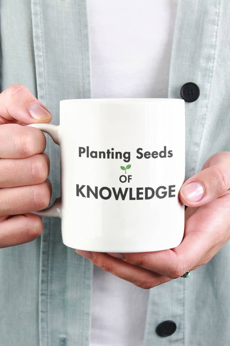 teacher mug with a person holding a white ceramic mug featuring the text 'Planting Seeds OF KNOWLEDGE' 