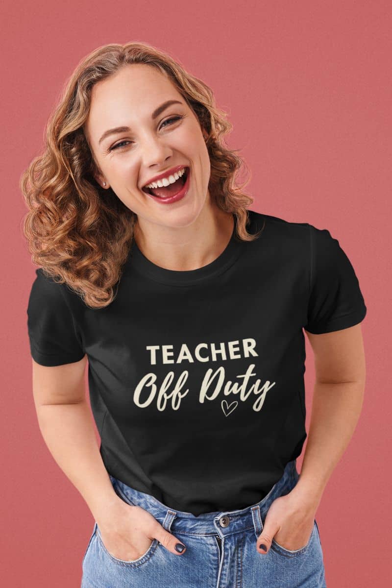 teacher quote shirt with a woman wearing a black t-shirt with a humorous quote 'Teacher Off Duty' on a pink background