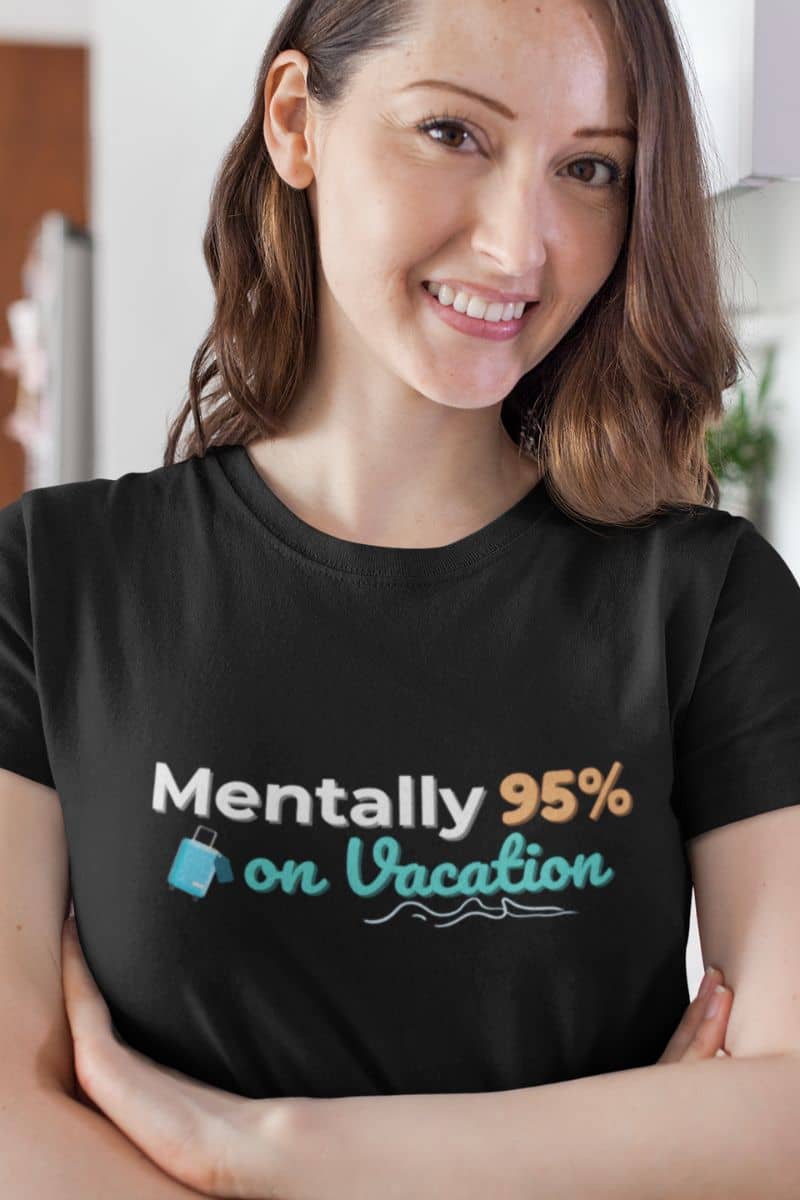 travel quote t-shirt with a woman wearing a black t-shirt with text 'Mentally 95% on Vacation' in a casual setting.
