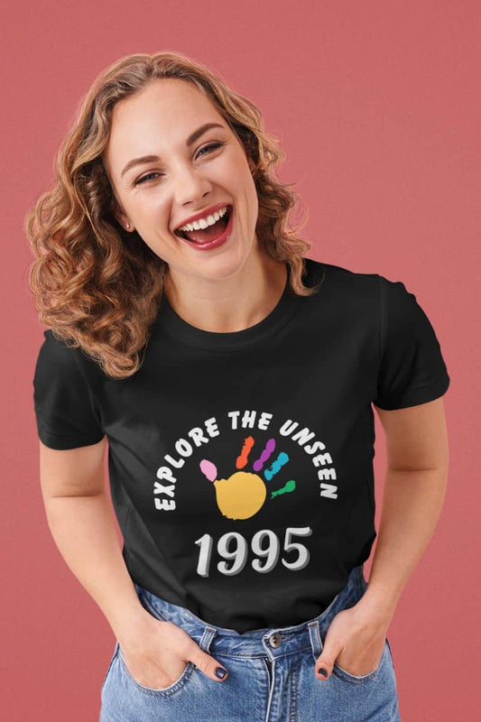 wanderlust t shirt with a woman wearing a black t-shirt with 'Explore the Unseen 1995' design on a pink background