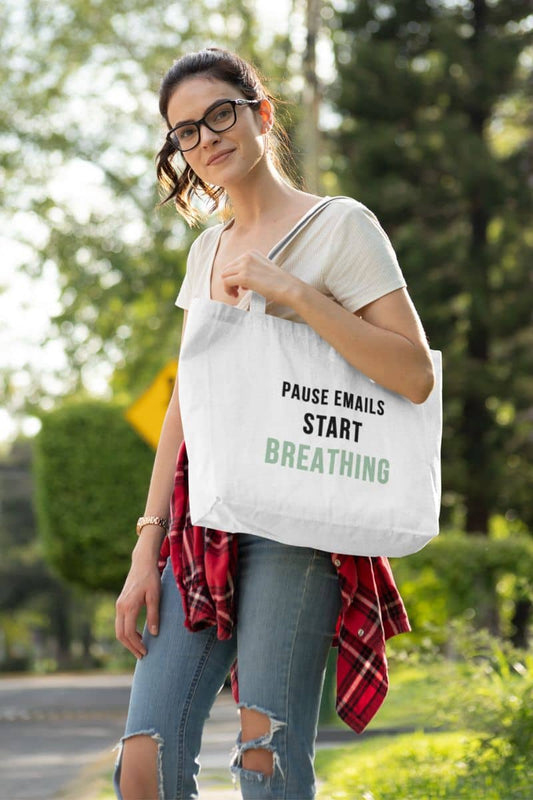 wellness tote bag with a woman holding a tote bag with text 'Pause Emails, Start Breathing' outdoors