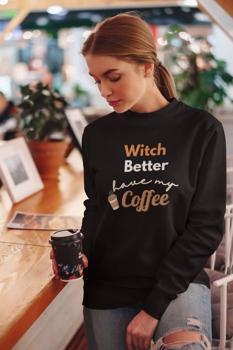 witchy sweatshirt displaying a girl wearing a black sweatshirt with text 'Witch Better Have My Coffee' in the coffee shop