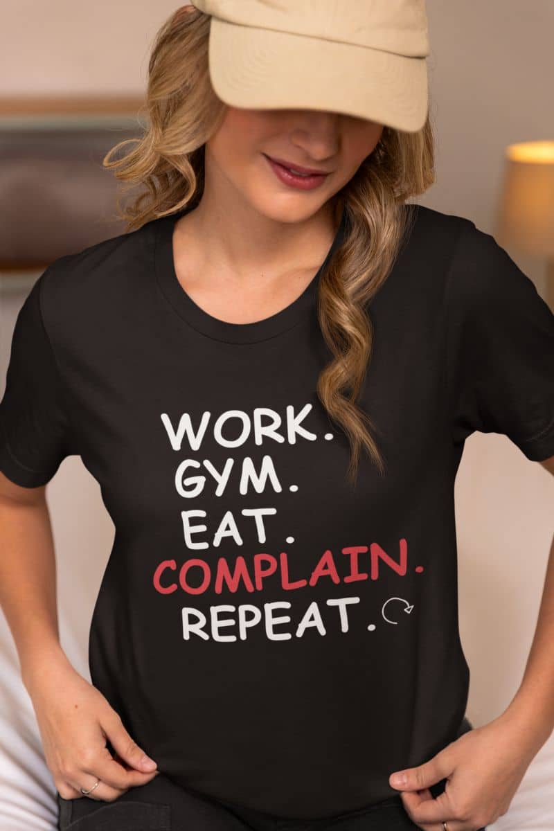 witty t-shirt design with a person wearing a black t-shirt with text 'Work. Gym. Eat. Complain. Repeat'.