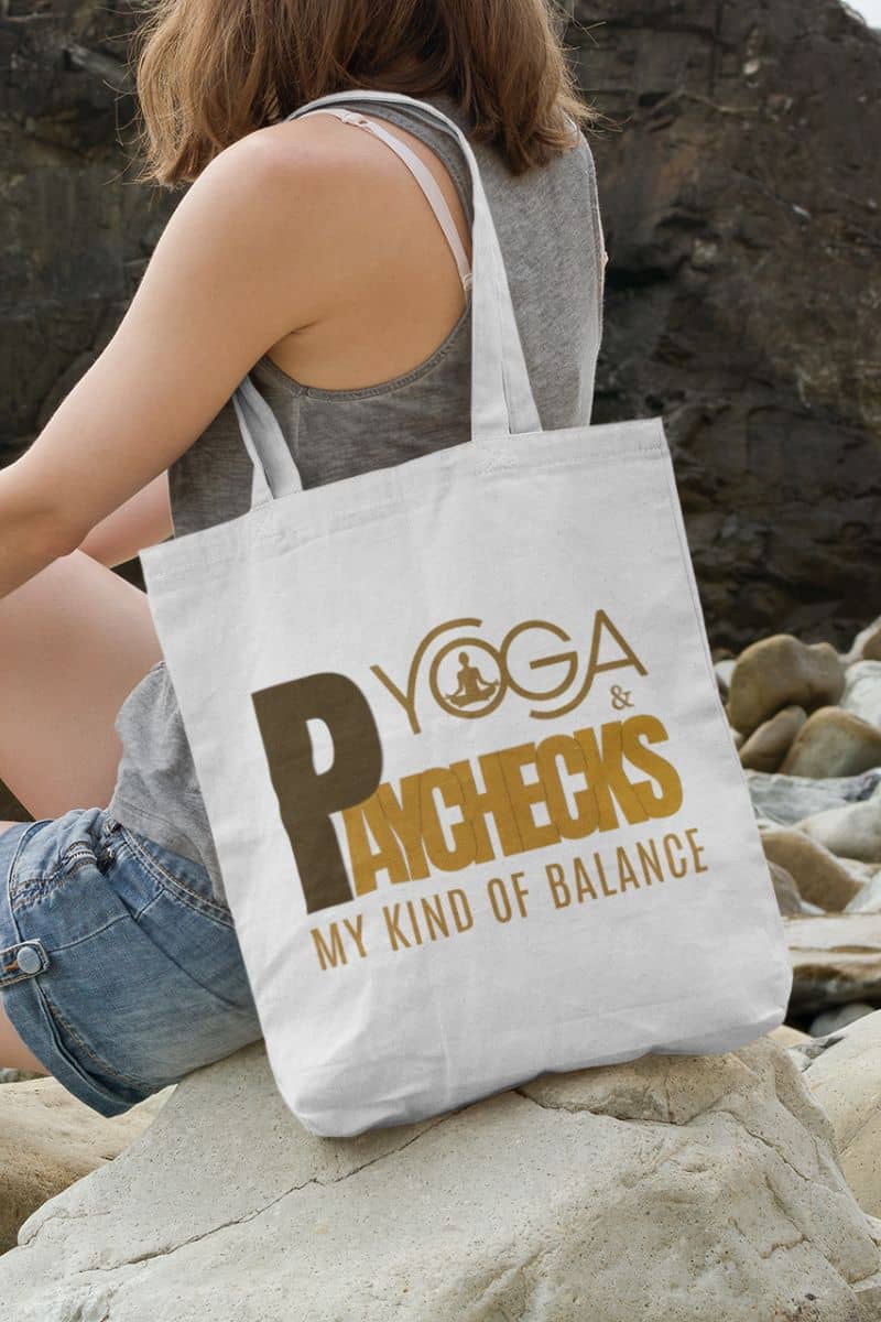 work and wellness carryall with a person sitting on rocks with a tote bag featuring 'Yoga & Pancakes: My Kind of Balance' text.