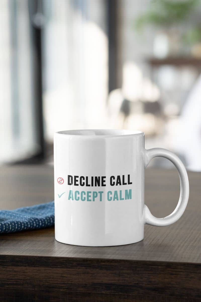 work life balance coffee mug with a white mug with text 'Decline Call, Accept Calm' on a wooden surface