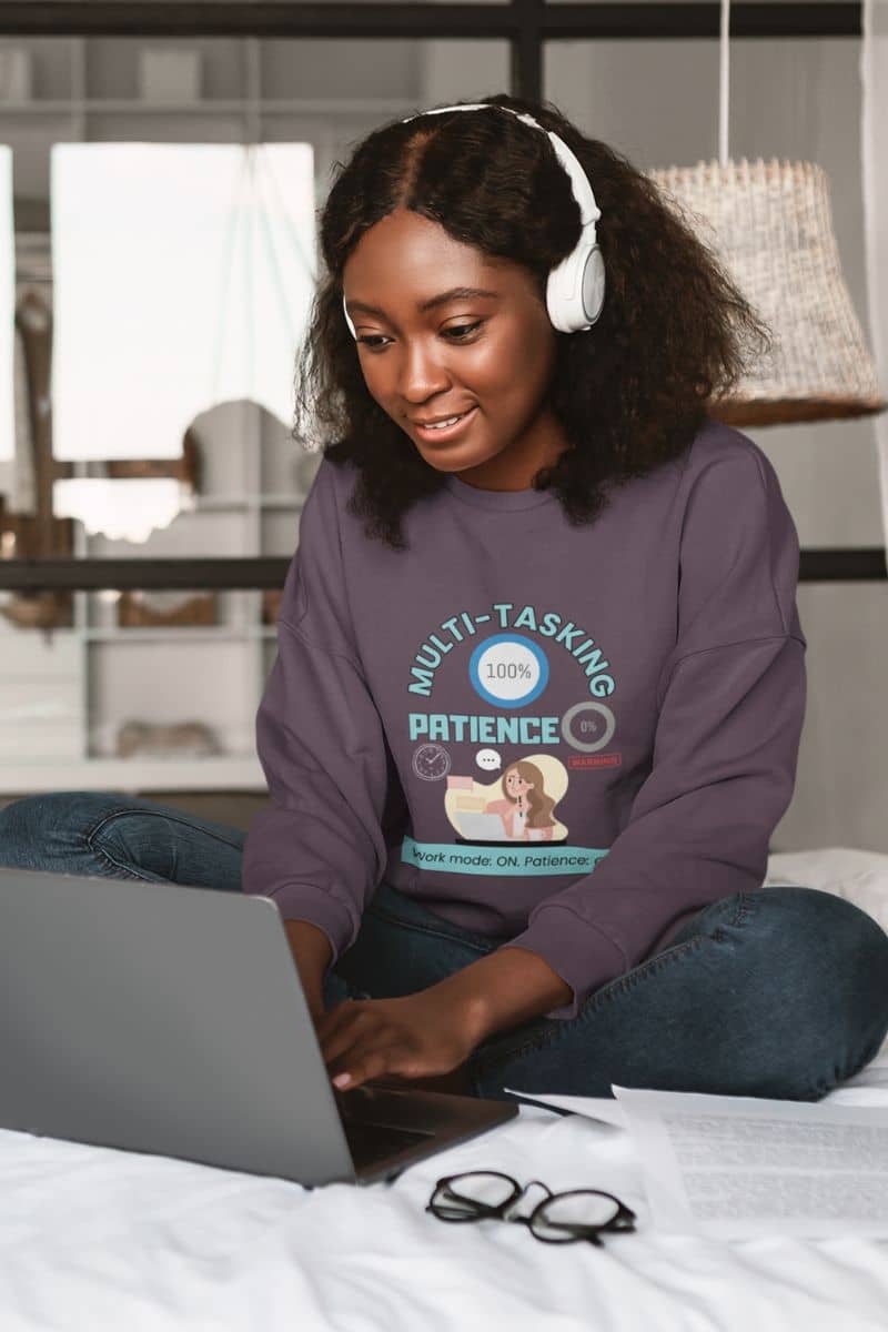 work-mode-sweatshirt with a girl working while listening to music in her bed