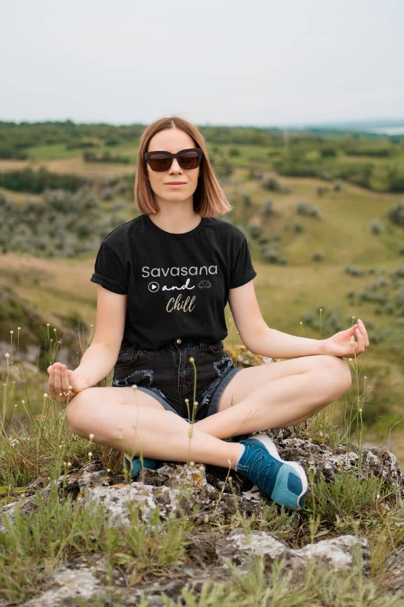 yoga lover shirt with a woman sitting in a meditative pose on a rocky outcrop with a scenic background
