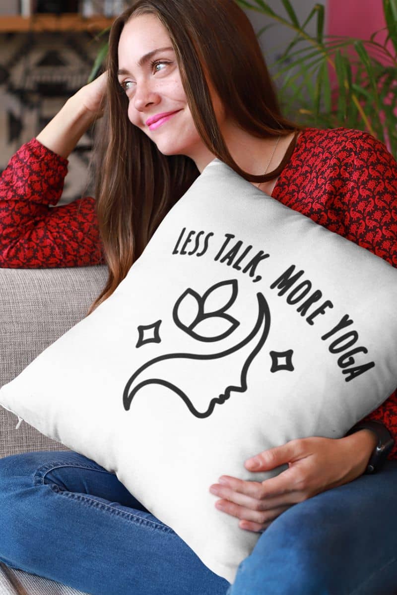 zen decor pillow with a woman holding a pillow with 'Less Talk, More Yoga' text and design.