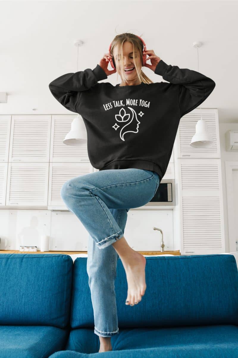 zen lifestyle sweater with a person wearing a black sweatshirt with 'Less Talk, More Yoga' text in a kitchen.