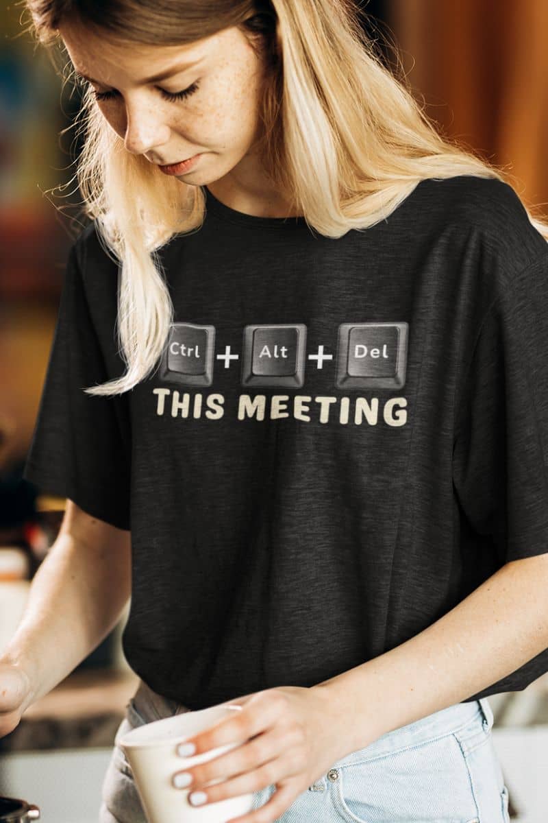 zoom meeting shirt with a person wearing a black t-shirt with text 'Ctrl + Alt + Del This Meeting' and holding a cup.